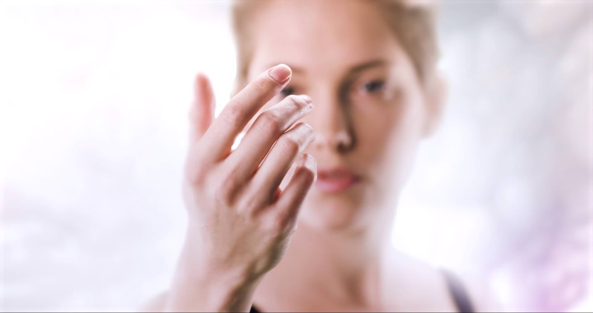 This image shows a female model looking at her own hand