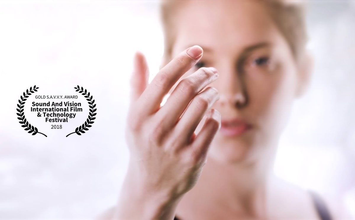 This image shows female model looking at her own hand with a laurel for Gold Savvy Award