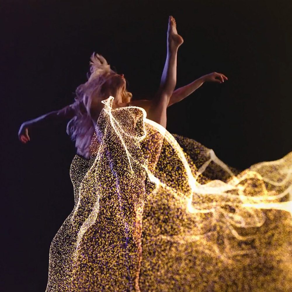 Female dancer surrounded by yellow particles 